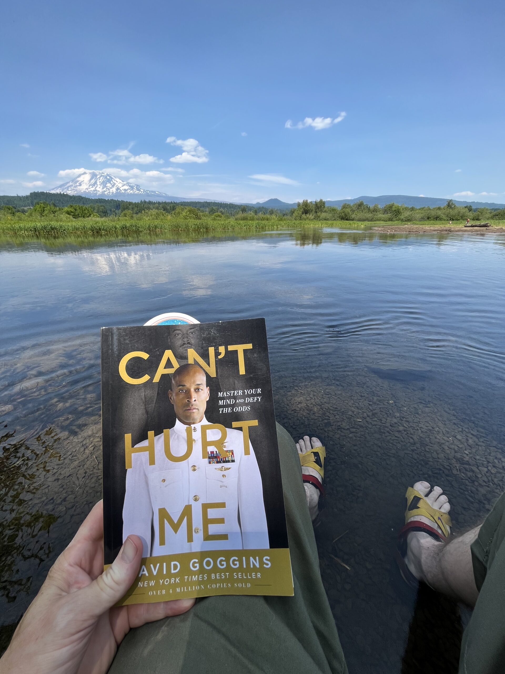 The book, Can't Hurt Me, by David Goggins—the picture has the book being held in front of Mount Adams in the United State of Washington